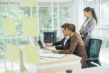 Businessman happy about his job with boss discussing while commenting a financial report document at meeting.