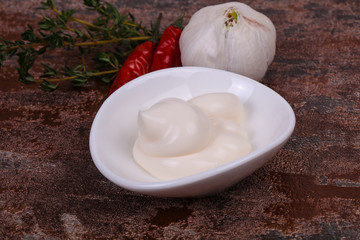 Mayonnaise sauce in the white bowl served thyme and garlic