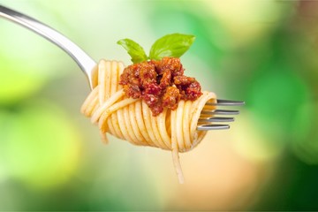 Spaghetti on fork with tomato sauce and parsley