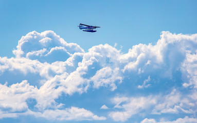 Small seaplane flying over stormy clouds 