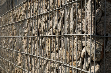Close-up on a steel, galvanized structure filled with spectacular pieces of rock.. Gabion.