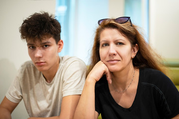 Fototapeta premium A middle-aged woman with his teenage son resting at the cafe and talking about teenage problems