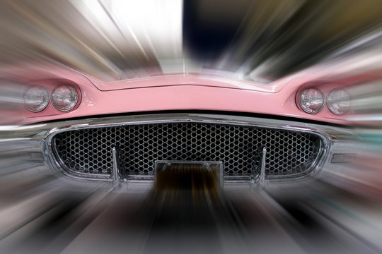 Frontaler Blick auf den Kühlergrill eines fahrenden Autos in pink