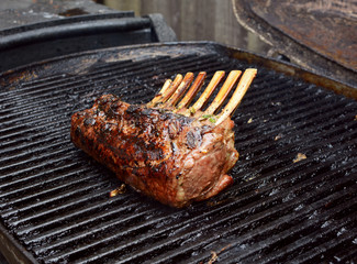 Juicy rack of lamb grilling on a summer barbecue