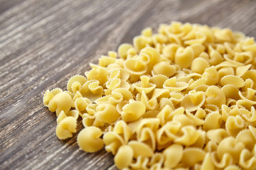 Funghetti pasta. Uncooked italian pasta on brown wooden table, closeup