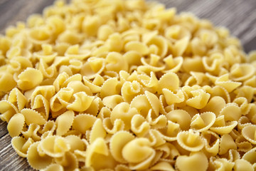Funghetti pasta. Uncooked italian pasta on brown wooden table, closeup