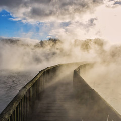 Un puente en el lago con vapor y humo por actividad geotermica