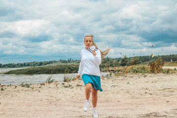 beautiful, slim woman with blonde pigtails resting, running, jumping on the shore of the sea.  vacation, joy, happiness, rest