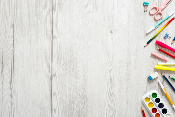 Back to school concept, creative layout with with various school supplies and stationery on wooden desk table. Flat lay style composition, top view, overhead. 