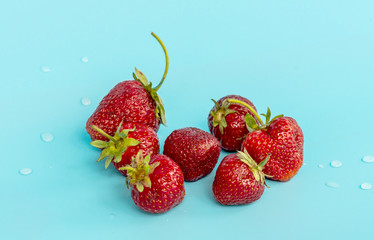 A bunch of strawberries with drops of water in a turquoise color
