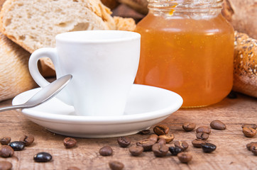 Delicious homemade jam, an espresso coffee cup, toasted coffee beans and bread background