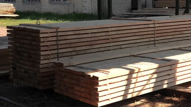 Piles of wooden boards in the sawmill, planking. Warehouse for sawing boards on a sawmill outdoors. Wood timber stack of wooden blanks construction material. Industry.