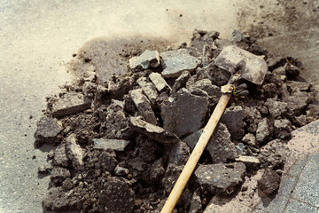 The shovel lies on a pile of old asphalt removed. Repair of roads.