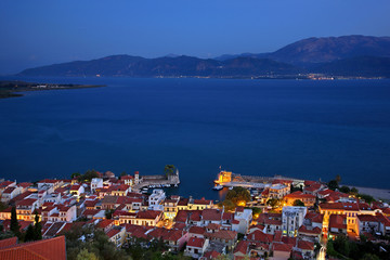  Night view of the picturesque little port of Nafpaktos (Lepanto) town from its castle. In the background the northern coast of Peloponnese. Aitoloakarnania, Greece.