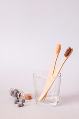 Bamboo toothbrush and dry tooth paste or toothpaste tablets on blue background. Zero waste, ecological concept.