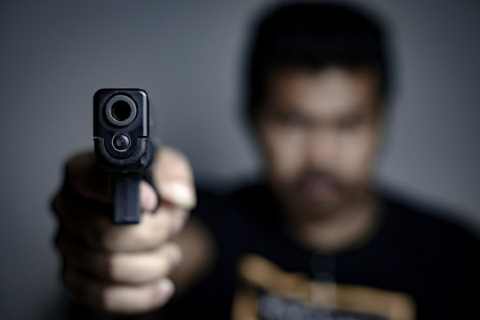 Man is shooting a gun , selective focus on front gun,use for add text 