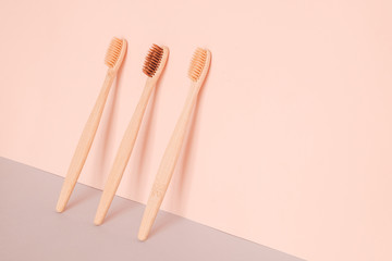 Bamboo toothbrush on pink blue background. Zero waste, ecological concept.