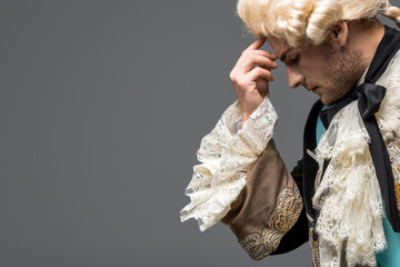 side view of pensive victorian gentleman in wig thinking isolated on grey