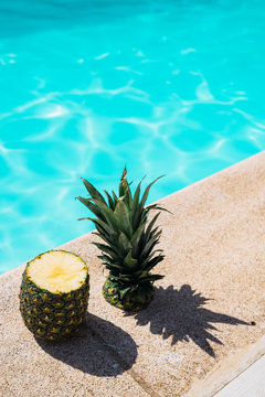 Cut Pineapple on the Edge of Swimming Pool. Pineapple in the Swimming Pool with Hard Shadow. Healthy Food Concept