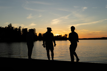 silhouette of three guys standing in a sunset 