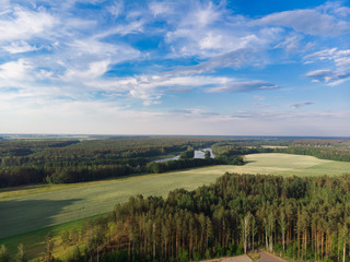 Fototapeta na wymiar Nature in the summer. Forests, fields, meadows, lake, river and village. View from the sky. The photo was taken by a copter. Panorama. The concept is a favorable environment. Blue sky. Background.