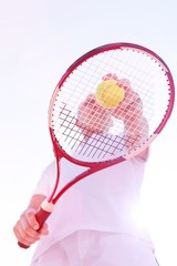 Low angle view of senior man playing tennis against clear sky on sunny day