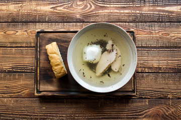 Chicken soup in a bowl on a wooden table.
