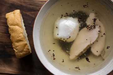 Chicken soup in a bowl on a wooden table.