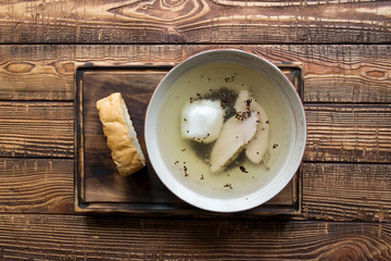 Chicken soup in a bowl on a wooden table.
