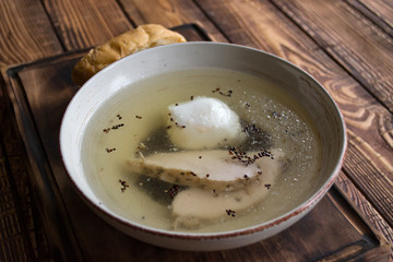 Chicken soup in a bowl on a wooden table.