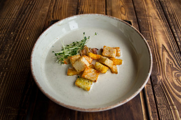 Cream soup in a plate, on a wooden table.