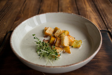Cream soup in a plate, on a wooden table.