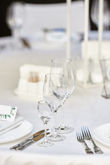 Table setting with sparcling wineglasses and cutlery on table, copy space. Menu mockup, place setting at wedding reception. Table served for wedding banquet in restauran
