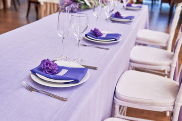 Table setting with white plates, flowers, wineglasses and cutlery on table, copy space. Menu mockup, place setting at wedding reception. Table served for wedding banquet in restauran