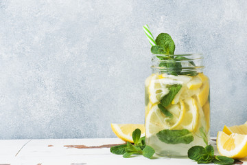 Detox water for healthy lifestyle. Fresh water in jar with lemon, cucumber and mint on wooden table. Copy space
