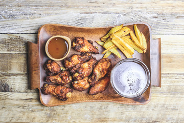 Grilled chicken wings on wooden background.