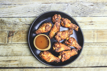 Grilled chicken wings on wooden background.