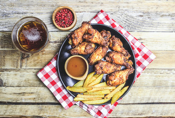 Grilled chicken wings on wooden background.