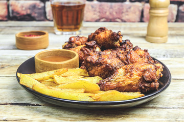 Grilled chicken wings on wooden background.