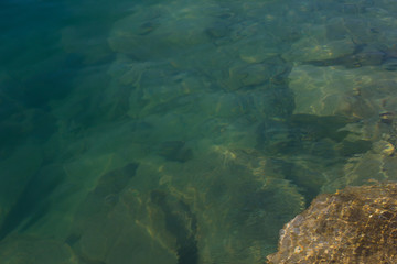 Fototapeta na wymiar Texture of water surface sun water stones waves - underwater world