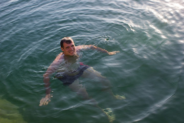 Male young swimmer on the water - summer sea