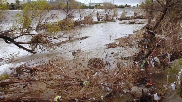 Flood damage and trash in the Los Angeles River after heavy rains.