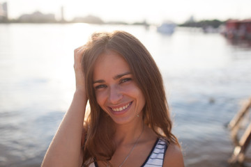 Closeup portrait of effective girl with long hair smiling to camera having fun on the beach,vacation mood