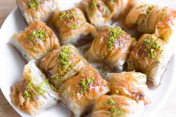turkish baklava. homemade baklava spilled with peanuts on white plate