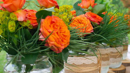 Beautiful orange roses in glass jars - close up