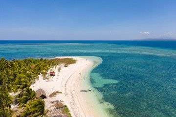 Tropical island Canimeran. White sandy beach on a desert island. Small island with palm trees and white sand.