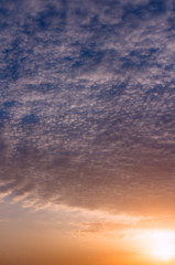 Naklejka na ściany i meble Sunset on the summer sky with beautiful clouds against the blue sky.