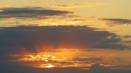 Sun rays at golden sky background at sunset