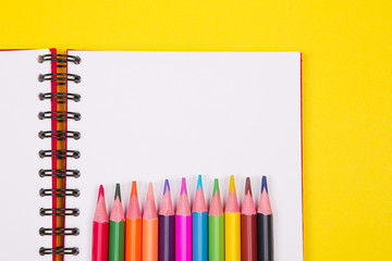 Colorful pencils and notebook with copy space on yellow background,education back to school, sale, shopping concept.