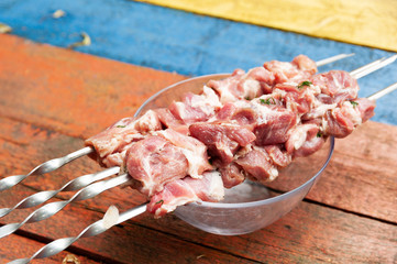Meat on skewers on a wooden background, cooking barbecue.